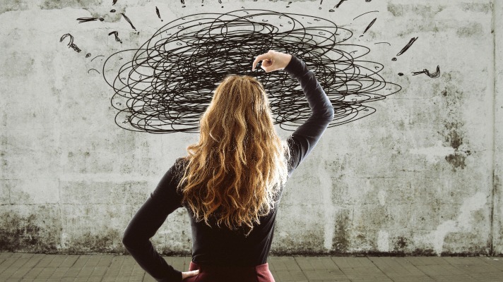 women looking at board with scribble and question marks