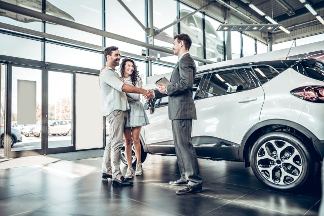 car dealership salesperson working with customers